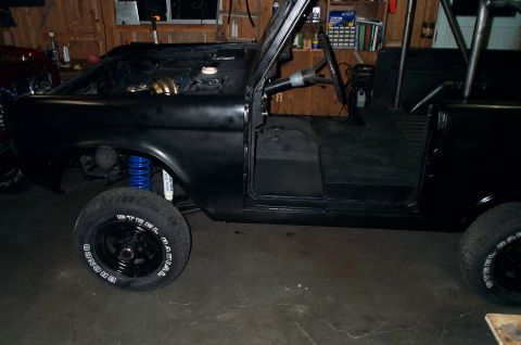 1967 Ford Bronco - This black 1967 Ford Bronco is shown in a workshop setting with its doors removed and an interior roll cage installed.