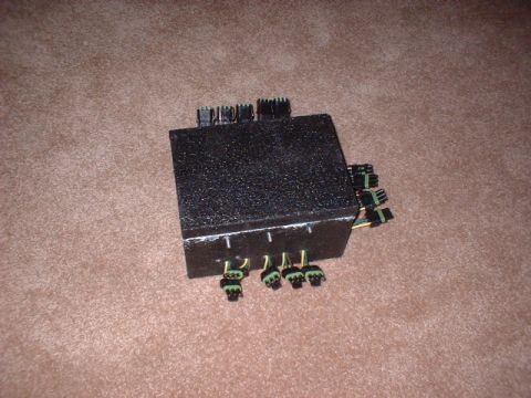 1986 Ford F-250 - This black electrical component has several green and black connectors attached to it.