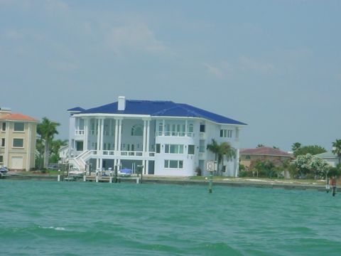 1973 Ford Ranchero - Large waterfront houses with blue roofs are visible under a partly cloudy sky.