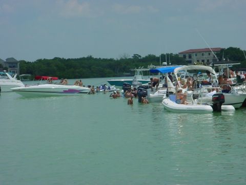 1973 Ford Ranchero - Boats are gathered together with many people swimming and socializing in the water.