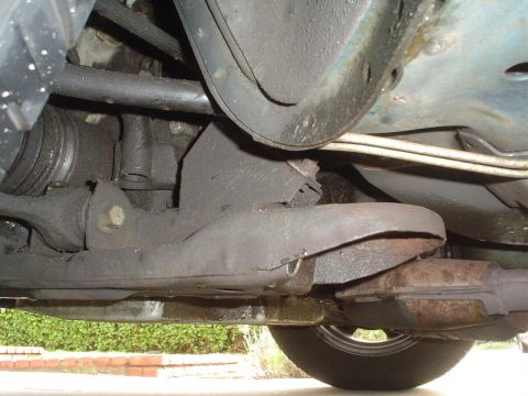 1993 Ford Taurus - A close-up view of a vehicle's undercarriage, showing mechanical parts and a tire.