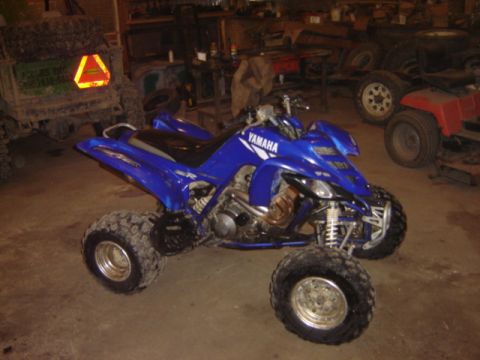 1992 Ford Bronco - A blue Yamaha ATV is parked in a garage with other vehicles in the background.