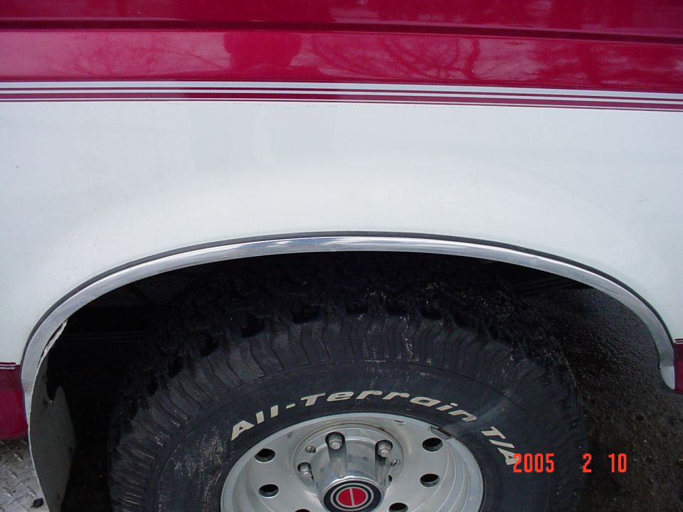 1994 Ford Bronco front passenger side wheel well with All-Terrain tire and red/white two-tone paint
