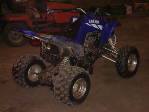 1992 Ford Bronco - A blue Yamaha ATV is parked indoors next to a red Simplicity riding mower.