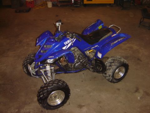 1992 Ford Bronco - A blue Yamaha Raptor ATV is shown from a three-quarter front view in a garage setting.
