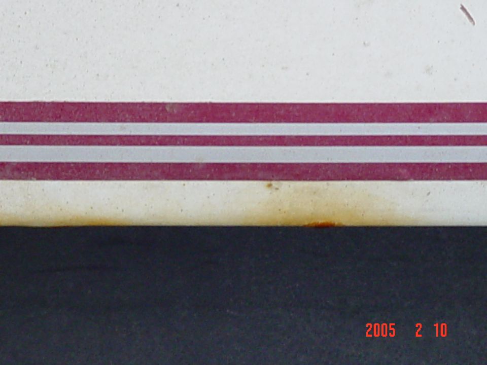 close-up of a white vehicle side with a red and silver stripe