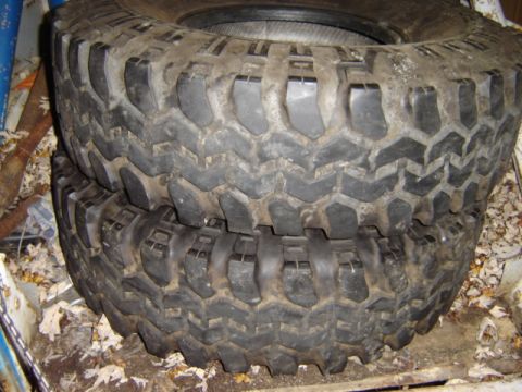 1992 Ford Bronco - A pair of off-road tires are shown stacked, a deep, aggressive tread for maximum traction.