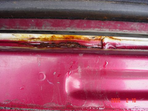 1994 Ford Bronco - Rust damage is visible on the door frame of a red vehicle.