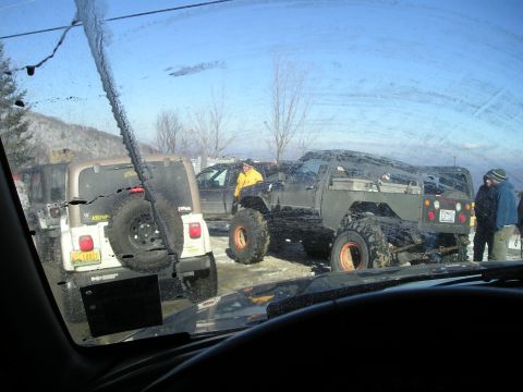 1996 Ford Bronco - Multiple off-road vehicles are gathered in a snowy environment, with a white Jeep Wrangler and a modified green truck being prominent.