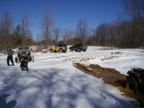 1996 Ford Bronco - Off-road vehicles tackle challenging snowy and muddy conditions on a bright, clear day.