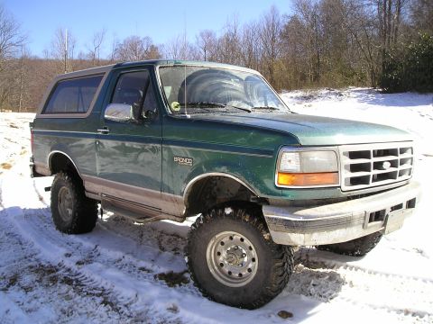 1996 Ford Bronco - A green 1996 Ford Bronco is shown from a 3/4 front angle on a snowy day.
