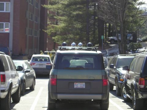 1996 Ford Bronco - Green SUV with roof rack and auxiliary lights is parked in a lot with other vehicles.