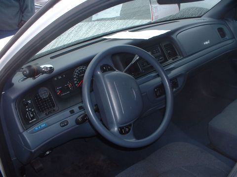 1999 Ford Crown Victoria - The interior of a 1999 Ford Crown Victoria, a blue dashboard and steering wheel.