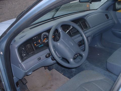 1999 Ford Crown Victoria - Interior view of a 1999 Ford Crown Victoria, highlighting the dashboard and driver's seat.