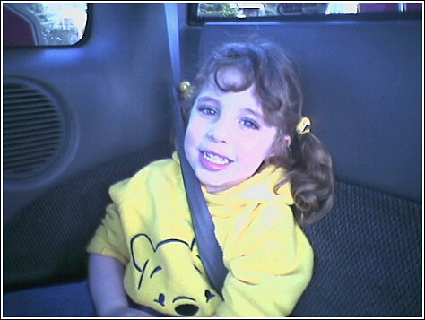 1993 Ford Bronco - A young girl with pigtails and makeup smiles while buckled into a car seat.