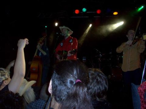 1988 Ford Bronco - A band plays music on stage in front of an audience.