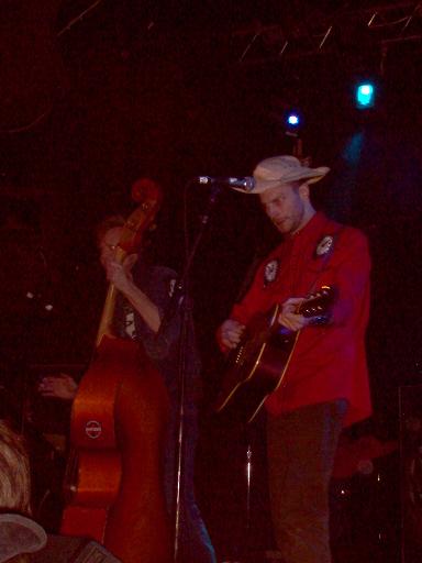 1988 Ford Bronco - Two musicians perform live on stage, one playing an upright bass and the other a guitar.