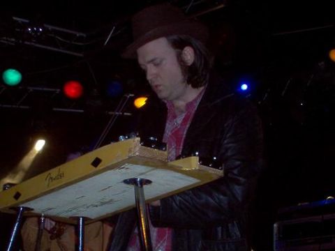1988 Ford Bronco - A musician performs on a Fender lap steel guitar during a live show, illuminated by stage lights.