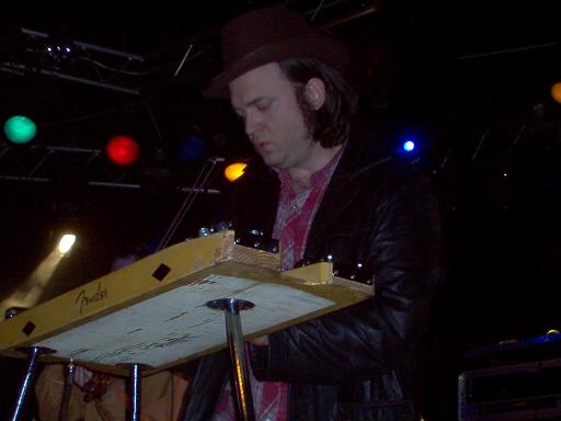 Man in hat plays yellow Fender lap steel guitar on stage