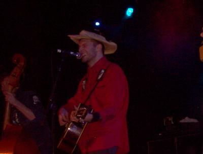 1988 Ford Bronco - Musicians perform live on stage, one with a guitar and cowboy hat, another with an upright bass.