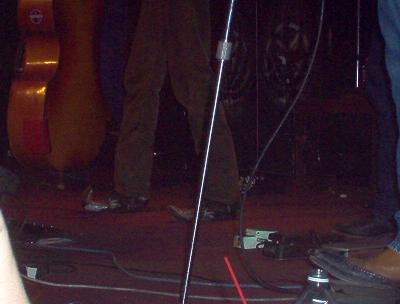1988 Ford Bronco - A dimly lit stage shows the lower bodies of musicians and musical instruments, suggesting a live performance.