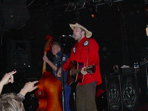 1988 Ford Bronco - A band plays live music on stage, with a singer in a cowboy hat and a double bass player visible.