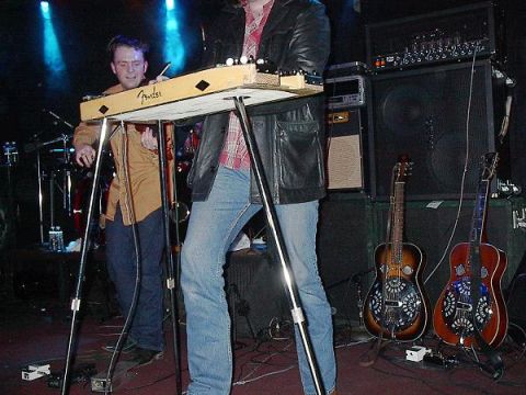 1988 Ford Bronco - Musicians perform on a stage with various instruments and amplifiers.