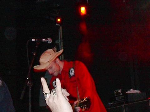 1988 Ford Bronco - A musician wearing a cowboy hat and red shirt performs on stage with a guitar.
