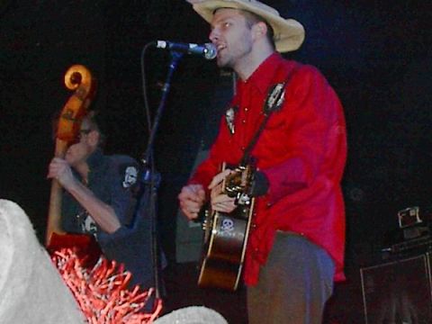 1988 Ford Bronco - Musicians perform live on stage with a microphone and instruments.
