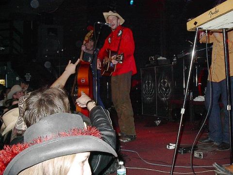 1988 Ford Bronco - A band performs live on stage for an audience, with musicians playing guitar and bass.