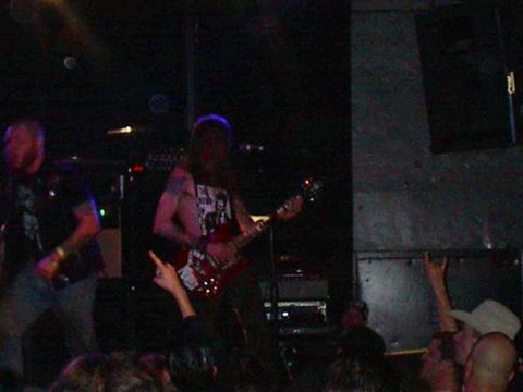 1988 Ford Bronco - A band plays live music on a dimly lit stage, with audience members visible in the foreground.
