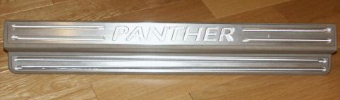 2001 Mercury Grand Marquis - A silver door sill plate with the word 'PANTHER' is shown on a wooden surface.