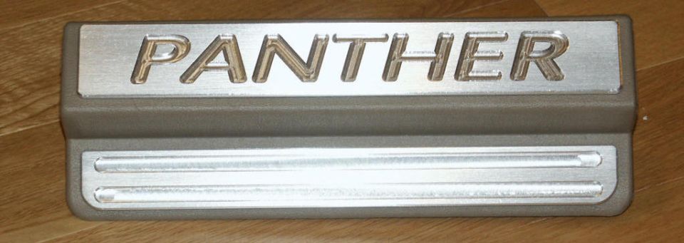 Custom door sill plate with brushed aluminum PANTHER lettering on tan plastic base