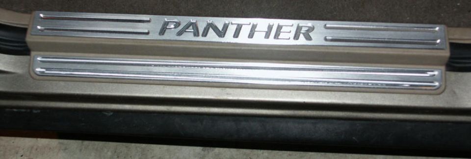 Door sill protector plate with "PANTHER" lettering and horizontal grooves
