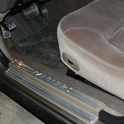 2001 Mercury Grand Marquis - Close-up of a car's interior door sill and pedals, with "PANTHER" text visible on the sill.