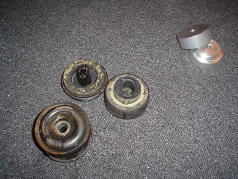 1993 Ford Taurus - Several worn car parts are laid out on a carpeted surface, including rubber mounts and metal spacers.