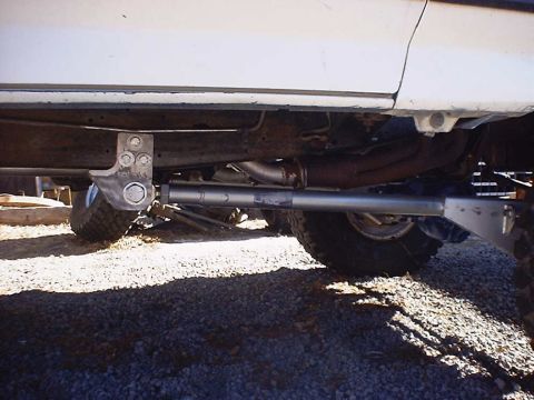 1988 Ford Bronco - Undercarriage view of a white vehicle, focusing on suspension modifications.