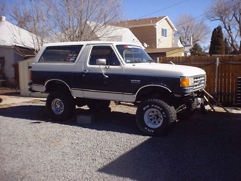 1988 Ford Bronco - This lifted Ford Bronco is parked outside a residential area on a sunny day.