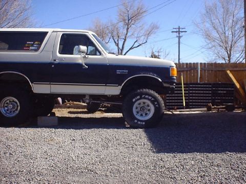 1988 Ford Bronco - This lifted 1988 Ford Bronco features a two-tone blue and white paint scheme and Bigfoot tires.