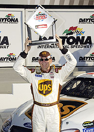 1973 Ford Ranchero - A race car driver celebrates a victory at Daytona International Speedway, holding the Daytona 500 trophy.
