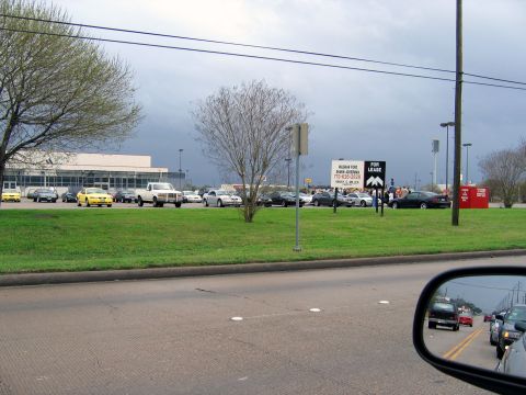 2000 Ford Crown Victoria - A view of a parking lot with several cars and a building in the background under a cloudy sky.