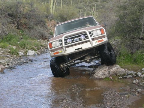1984 Ford Bronco - This modified Ford Bronco navigates rocky terrain in a desert environment.