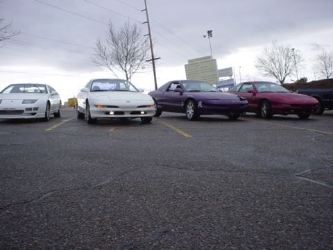 1993 Ford Probe - Four Ford Probe cars are parked in a lot, with a Nissan 300ZX on the far left.