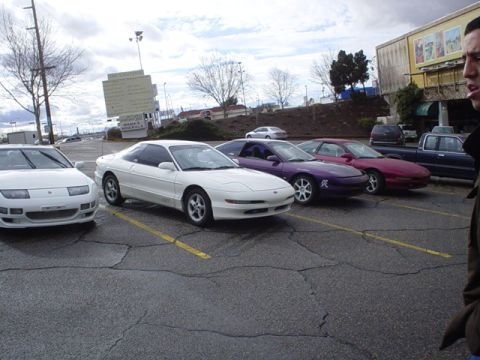 1993 Ford Probe - Several Ford Probes are parked in a lot under an overcast sky.