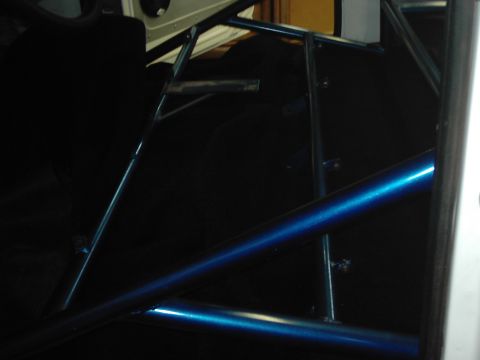 1978 Ford Bronco - The interior of a vehicle shows a custom blue roll cage structure.