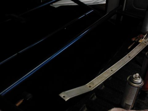 1978 Ford Bronco - The interior of a vehicle shows a black panel with blue trim and a metal bracket. A can of spray paint is also visible.