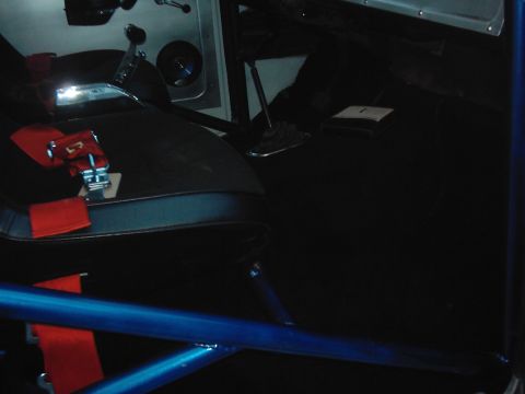 1978 Ford Bronco - The interior of a vehicle is shown, a racing seat with a red harness and a blue roll cage, suggesting a performance or off-road modificatio…