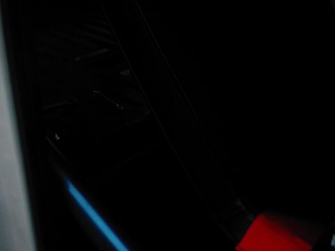 1978 Ford Bronco - A close-up shot reveals a dark interior with a blue accent light and a partial red logo at the bottom right.