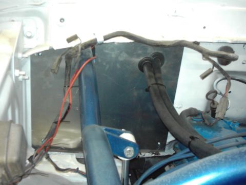 1978 Ford Bronco - Close-up view of engine bay components, including wiring and hoses, with a blue metal bracket.