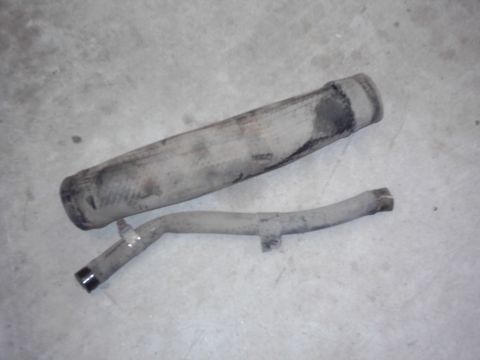 1978 Ford Bronco - Exhaust system components lie on a concrete surface, showing signs of wear and use.
